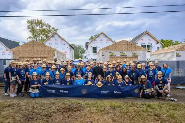 A group of Notre Dame employees pose in front of the Habitat Homes built as part of Father Bob's inaugural events.